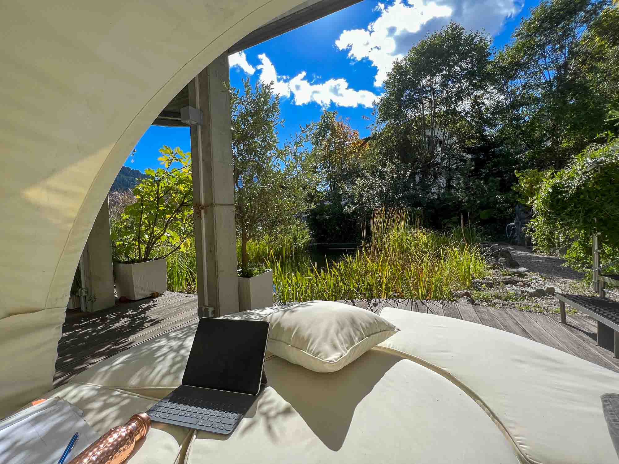Schreibplatz mit Blick ins Grüne: iPad auf Gartenliege am Naturteich in der Sonne