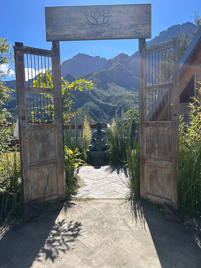 Steinerner Buddha im Freien im Hintergrund die Berge von Cilaos – Symbol für Ruhe.
