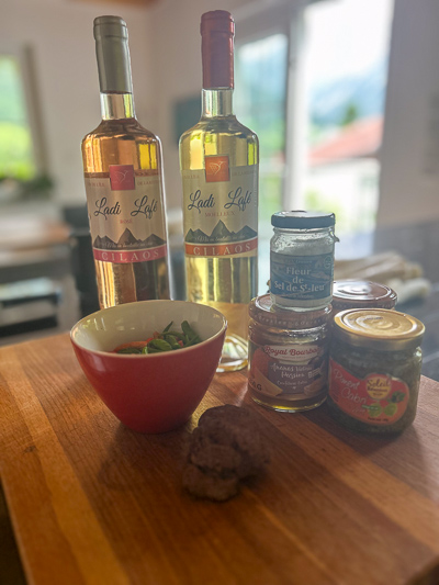 Mitbringsel aus La Réunion auf einem Küchentisch: zwei Weinflaschen, Fleur de Sel, Piment Cabri und kleine Gläser – schlicht arrangiert.