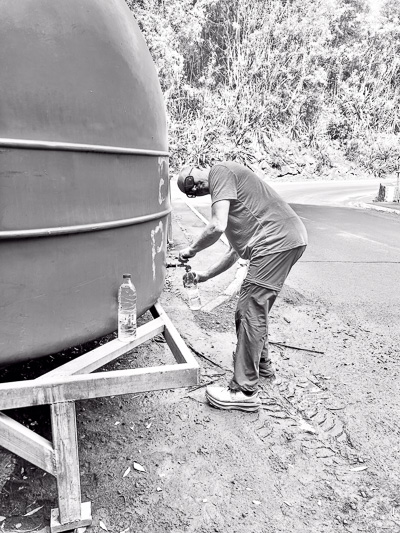 Ulf beim Wasserholen an einem Tank am Straßenrand auf La Réunion