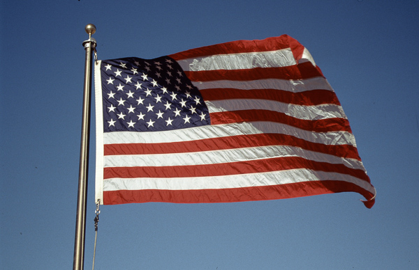 US-amerikanische Flagge im Wind vor blauem Himmel – Symbol für Aufbruch und Austausch