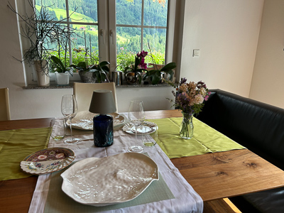 Gedeckter Tisch, leere Gläser, ein Hauch von Heimkehr – der Abend legt sich auf das Holz.
